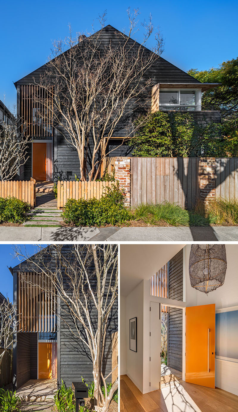 A colorful front door stands out and adds a pop of color to this mostly black Australian house.