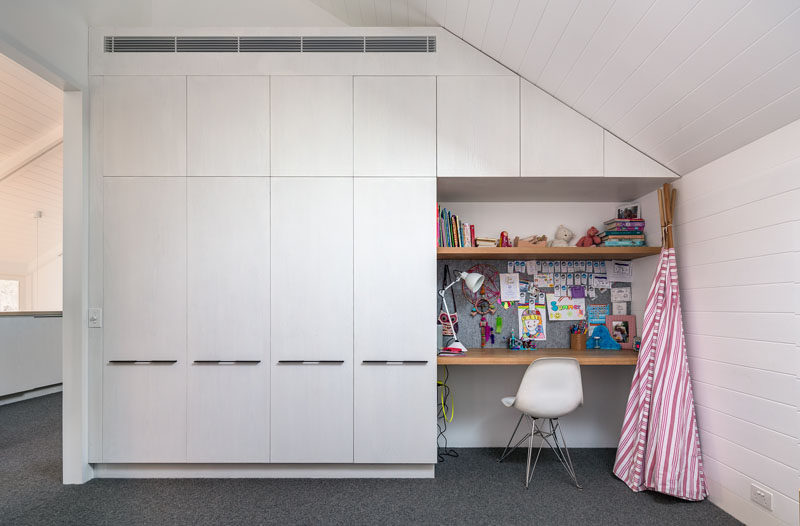 Custom built-in white cabinetry makes the most of the space, and a small desk is perfect for homework.