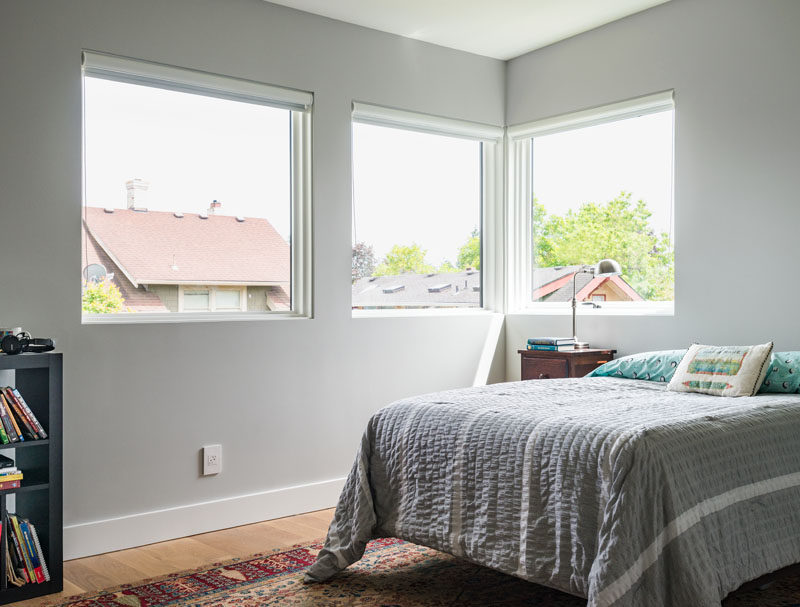 In this kid's bedroom, light gray walls are paired with custom white oak wooden flooring for a soft modern look.