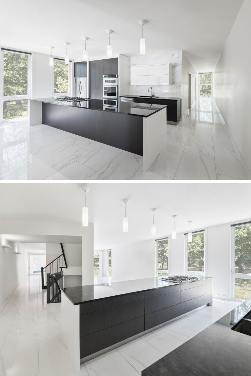 The dark cabinetry and kitchen island contrast with the white walls and marbled floor.
