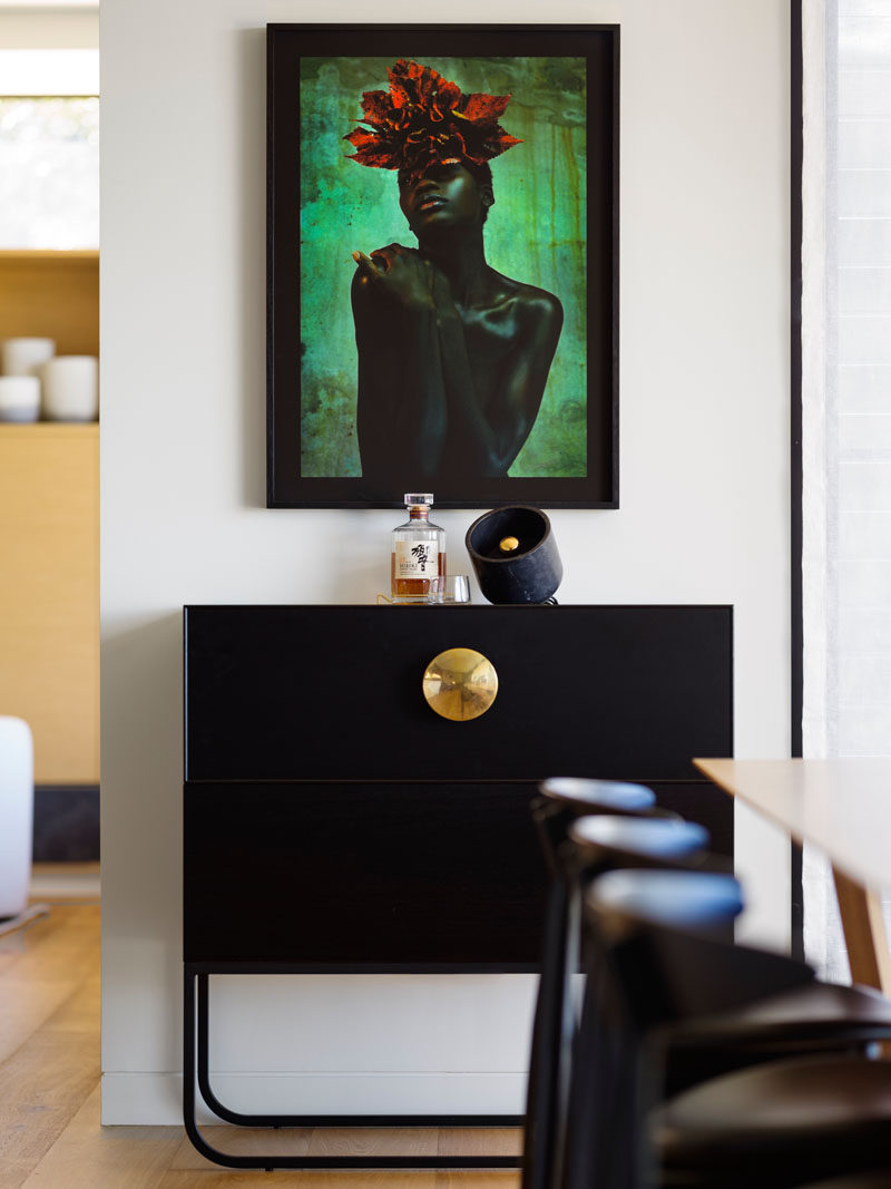 Beside the dining area, black framed artwork makes a dramatic statement.