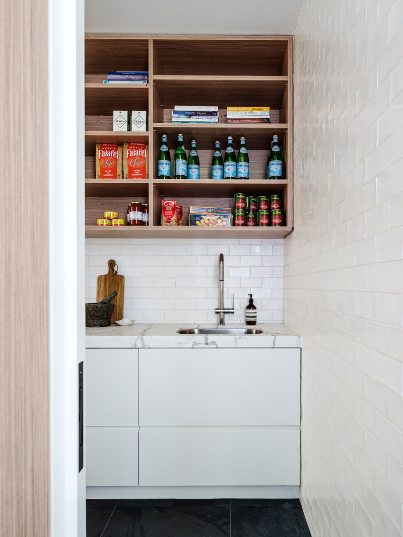 This home has a walk-in pantry room hidden behind the kitchen.