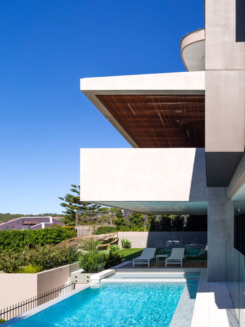 This Australian home opens up to a glass-enclosed swimming pool with another deck for lounging.