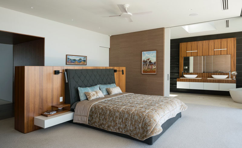 This master bedroom has sliding doors that open up to reveal an ensuite bathroom.