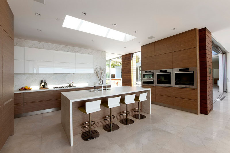 In the kitchen, the upper white cabinets match the island, with all of the other cabinets made from wood.