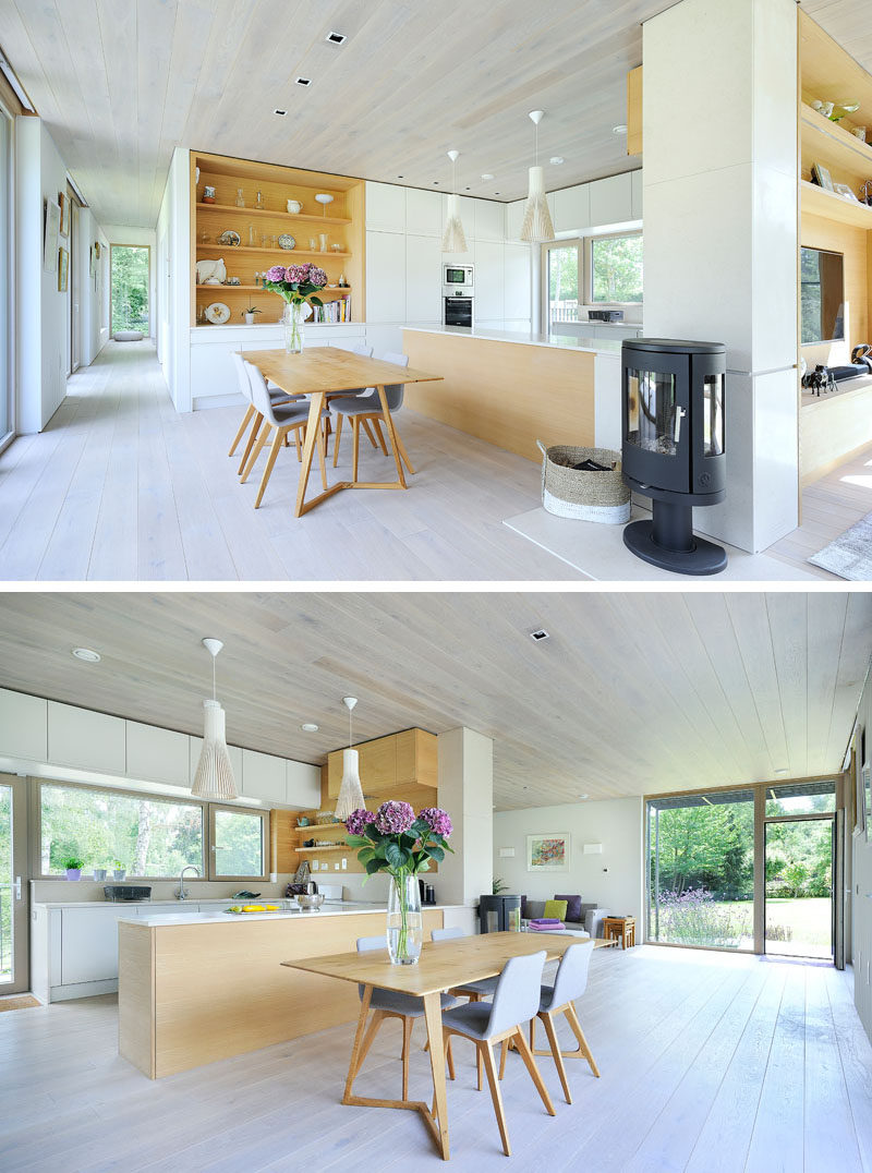 This living room has built-in cabinetry, and around the corner is the dining room and kitchen. A wood fire between the living and dining room heats the space.