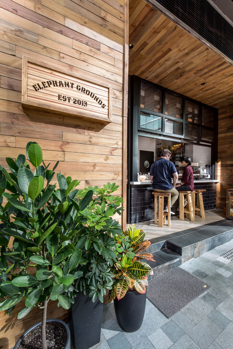 This cafe has a simple color palette of wood, white and black, with a touch of green from the plants.