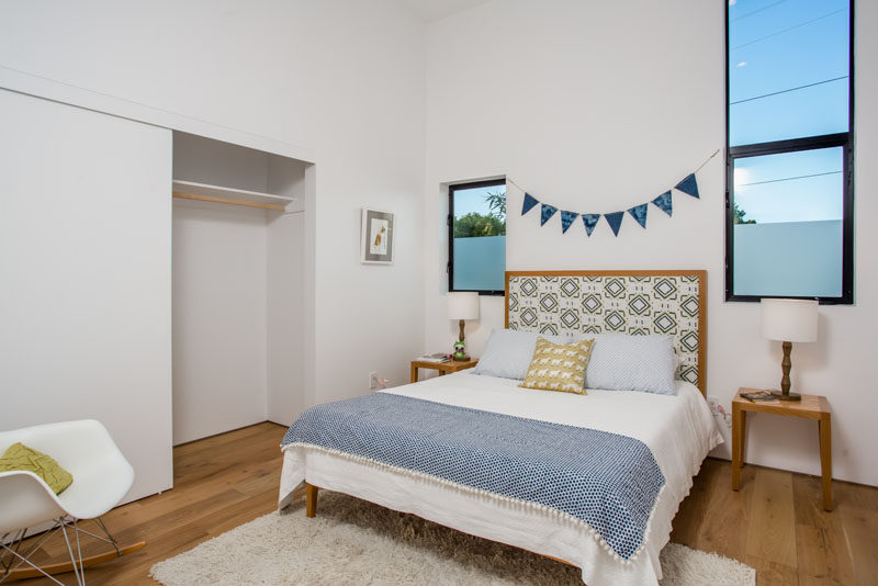 This bedroom has a built-in wardrobe, and partially frosted windows provide privacy.