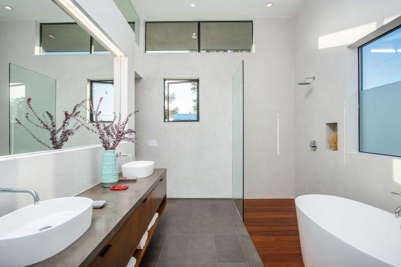 In this ensuite bath, there's a double vanity, bath and walk-in shower with built-in shelf, and the window on the right has been partially frosted for privacy.