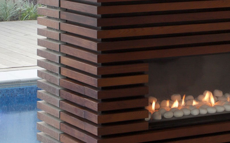 Wrapping an unsightly pillar or inconvenient wall in wood slats and installing a television and fireplace within its design, is a great way to turn otherwise dead space in your home into a functional and unique design detail.