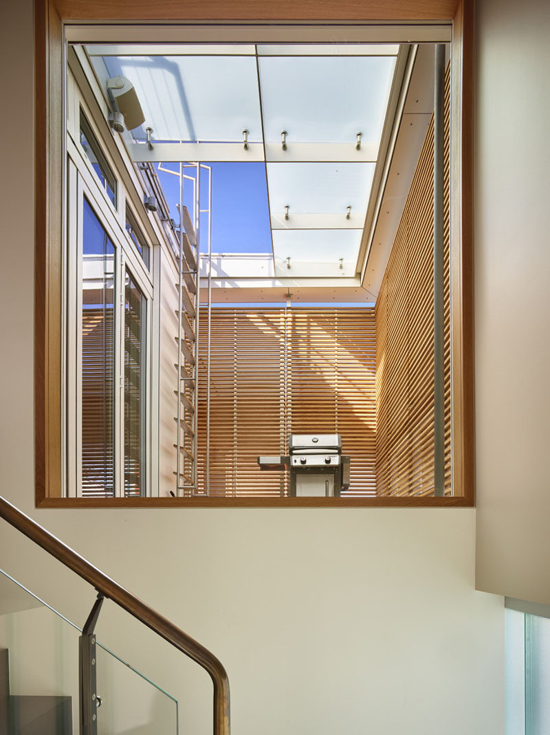 When walking up these stairs, a large window provides views of a small terrace with a barbeque (located off the kitchen), and a ladder that provides access to the roof deck.