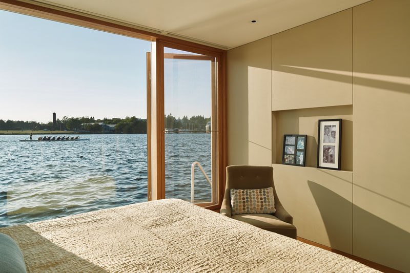 The bedroom in this floating home has a wall made of windows, allowing for picturesque views of the water.