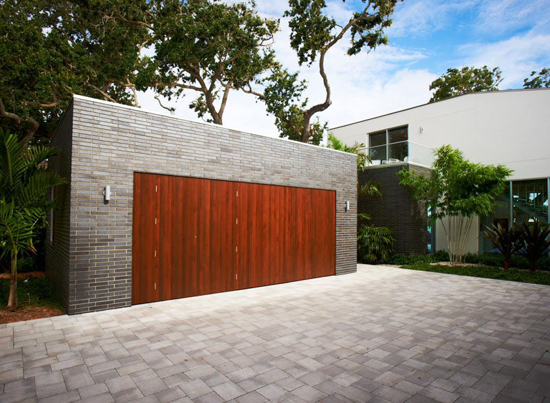 18 Inspirational Examples Of Modern Garage Doors // The rich colored wood of these garage doors, stands out and contrasts the brick.