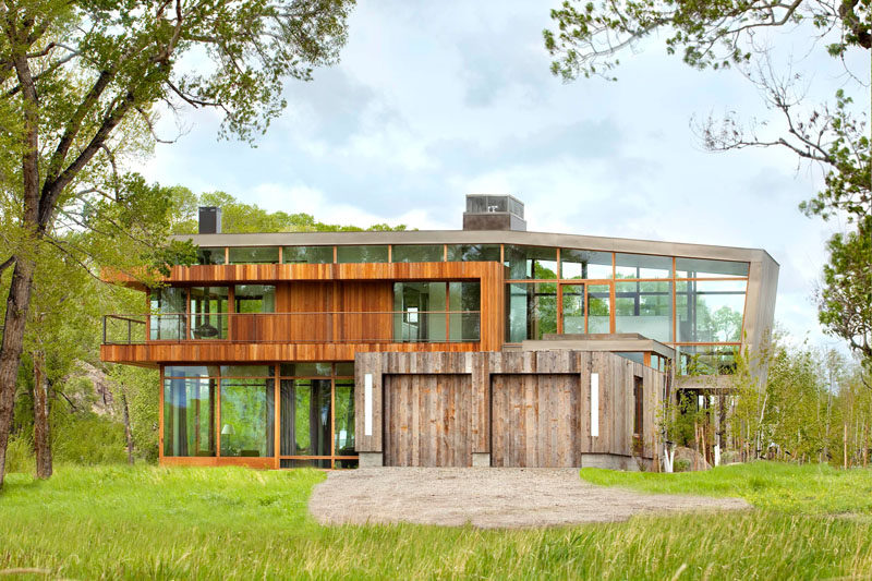 18 Inspirational Examples Of Modern Garage Doors // The reclaimed wood used to create this two car garage has a seamless look and ties back in with the surrounding nature.