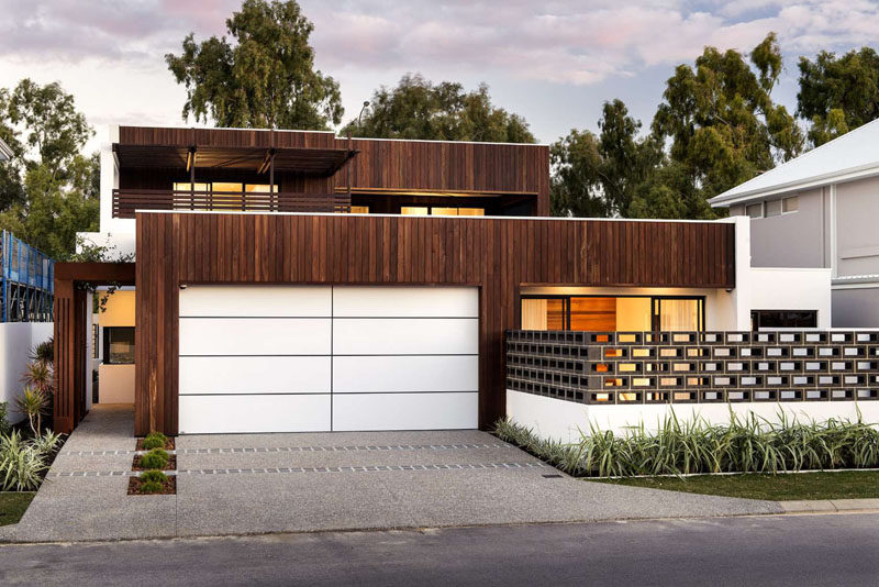 18 Inspirational Examples Of Modern Garage Doors // The bright white garage door with its dark lines, contrasts the wooden exterior in an unexpected and modern way.