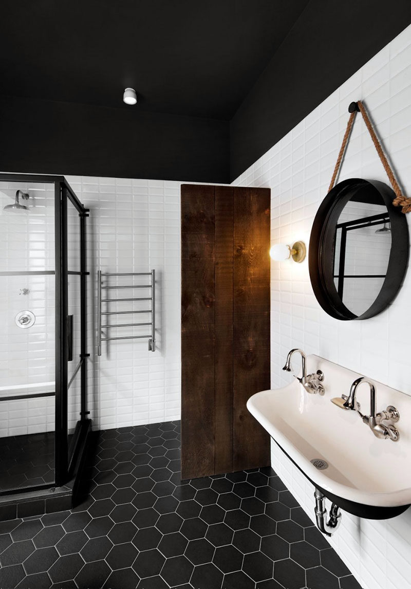 8 Examples Of Tile Flooring With Geometric Patterns // This bathroom uses simple black hexagonal tiles to create a modern and dramatic geometric floor.