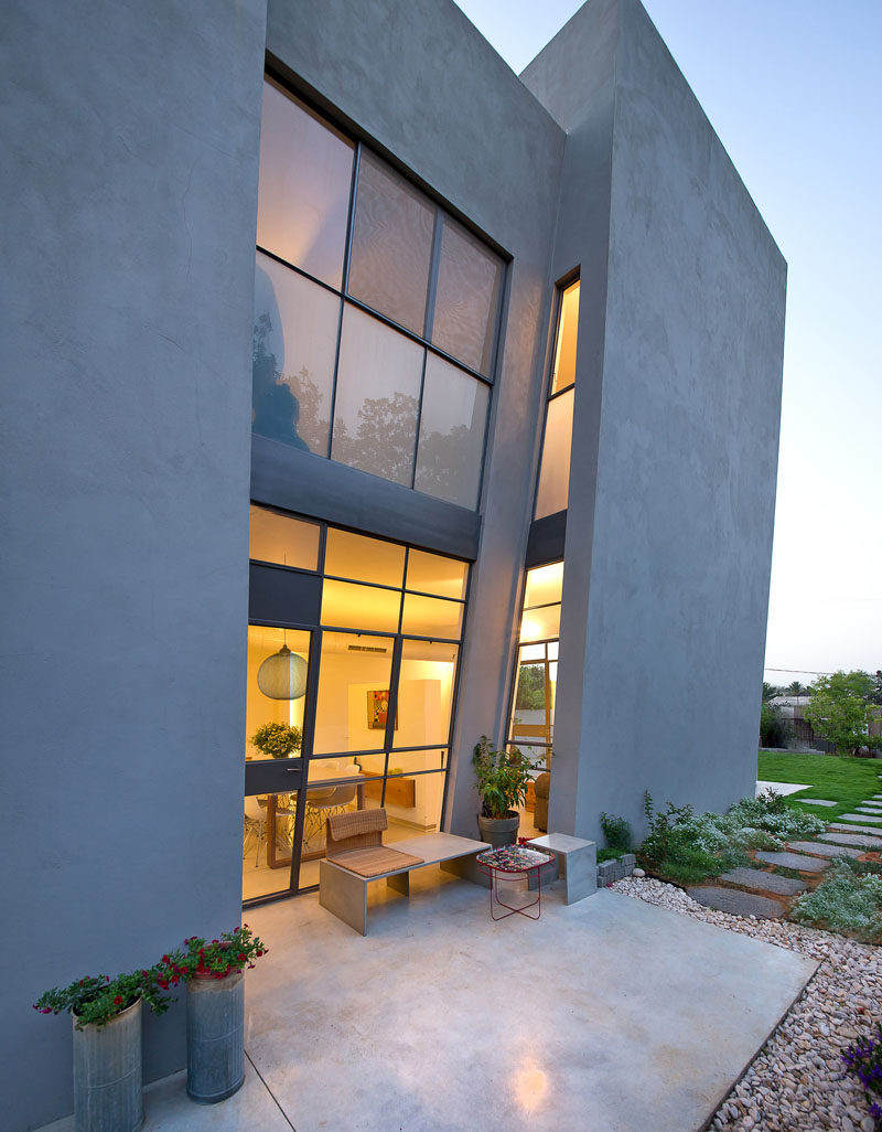 This home in Israel has a slanted wall that towers over the outdoor patio.