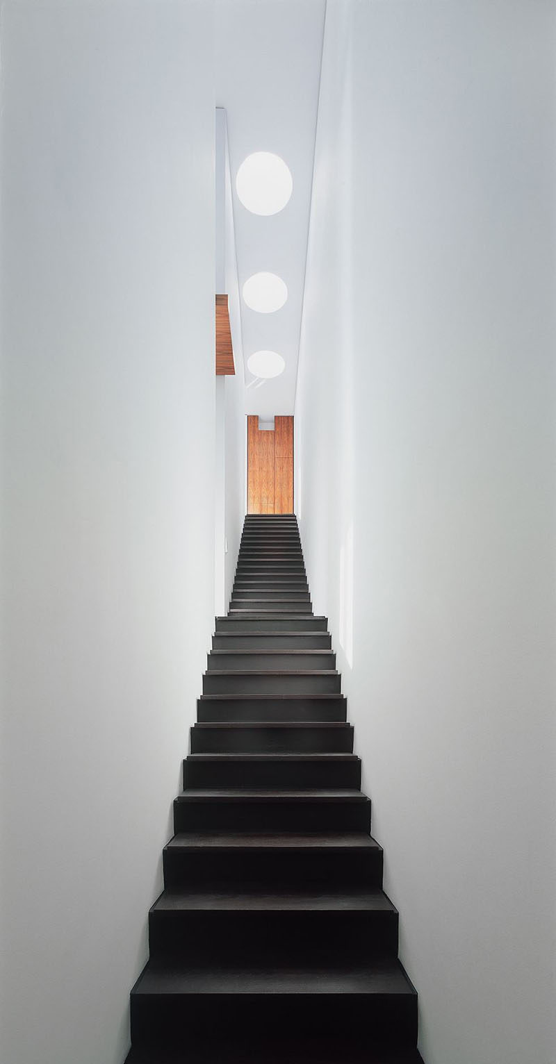 This single-flight stair way, which is lit from above, connects all three levels of this house.