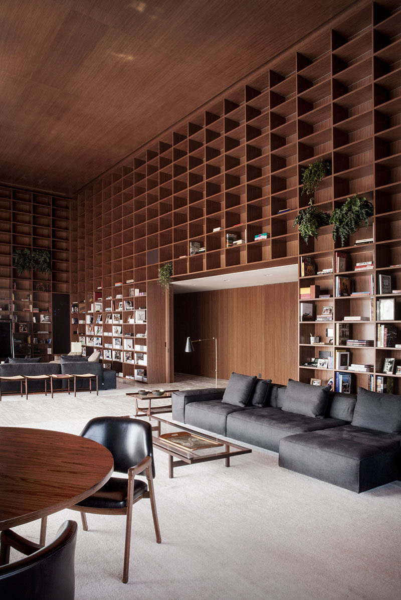 A double height room with floor-to-ceiling wooden shelves