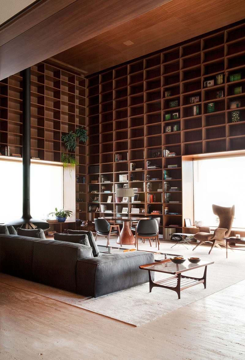 A double height room with floor-to-ceiling wooden shelves