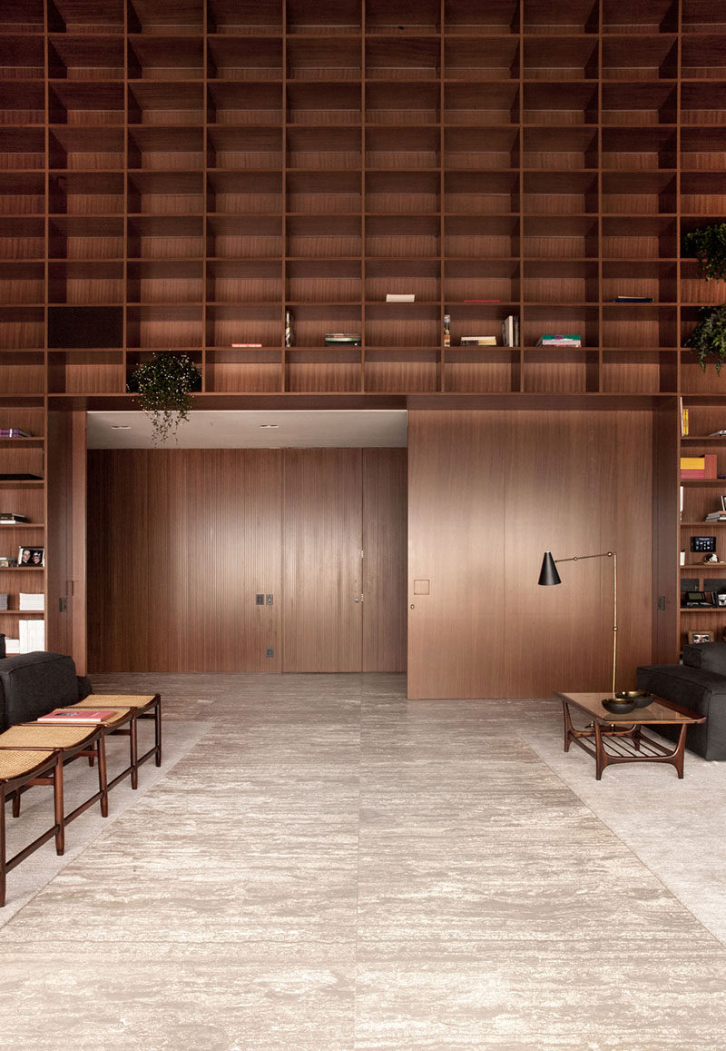 A double height room with floor-to-ceiling wooden shelves