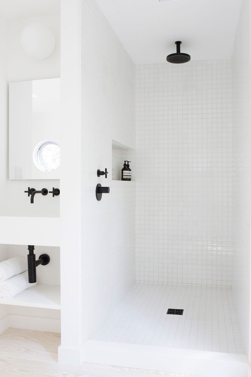 6 Ideas For Creating A Minimalist Bathroom // Create Contrast --- Even though the walls should be kept fairly light, bringing in darker elements, like black hardware, can make a bold statement without bringing in unnecessary objects.