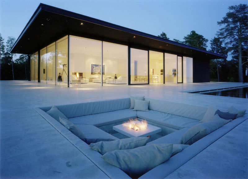 15 Outdoor Conversation Pits Built For Entertaining // Cozy cushions and the square fireplace in this built in conversation pit would make for the perfect place to stargaze or peacefully enjoy a cup of hot chocolate. #ConversationPit #FirePit #YardIdeas