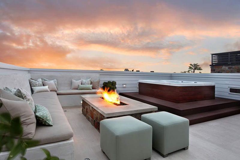 15 Outdoor Conversation Pits Built For Entertaining // This built-in rooftop conversation pit features a hot tub and fire, perfect for chilly nights. #ConversationPit #FirePit #YardIdeas