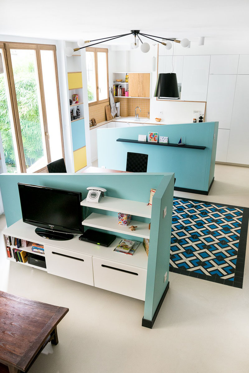 This small apartment uses half walls to create separate spaces for the kitchen, dining and living room.