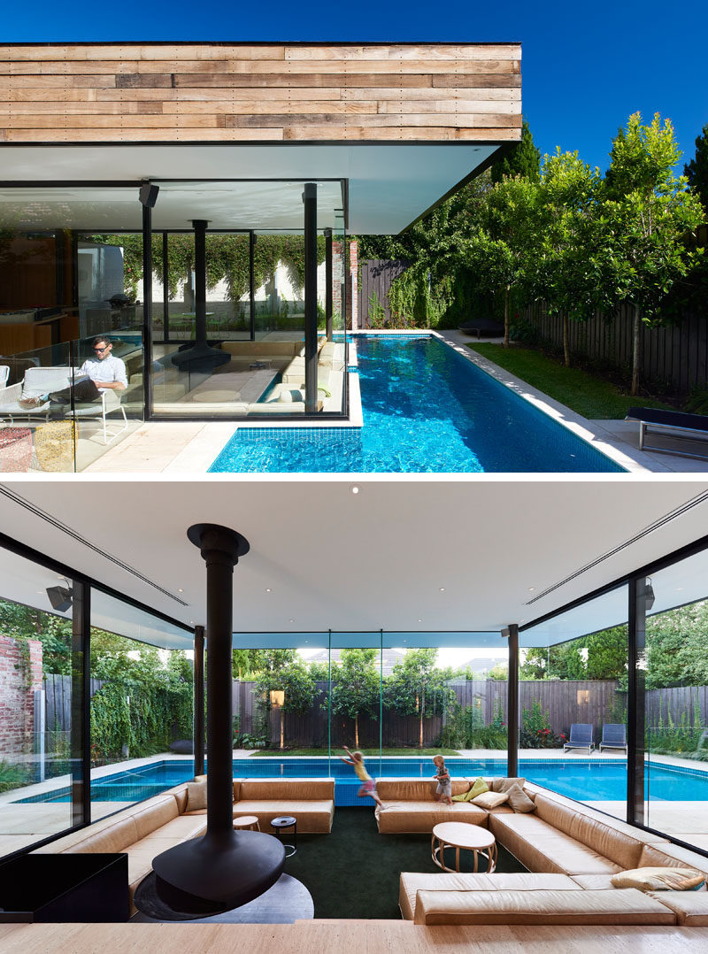 This Australian home features a small lap pool in the backyard and a sunken living room that sits at eye level with the pool.#SunkenLivingRoom #SwimmingPool #Fireplace #LivingRoom