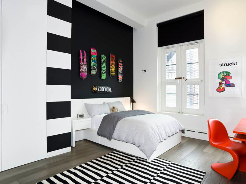 14 Inspirational Bedroom Ideas For Teenagers // Hanging graphic skateboards personalizes a space and can make a statement when brightly colored boards are contrasted against an all black wall.