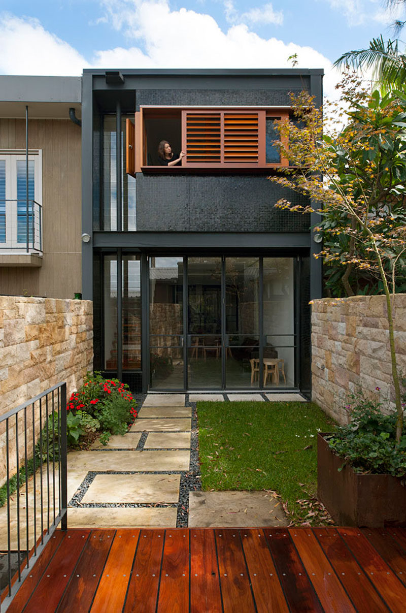 Wooden shutters contrast the black facade of this Australian home.