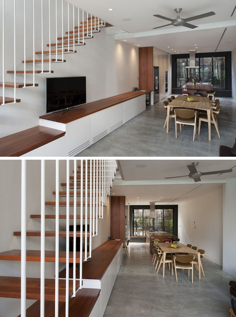 The living room, dining room and kitchen in this home share the same space, with built-in cabinetry lining the wall under the stairs. It also continues into the kitchen, allowing for plenty of storage.