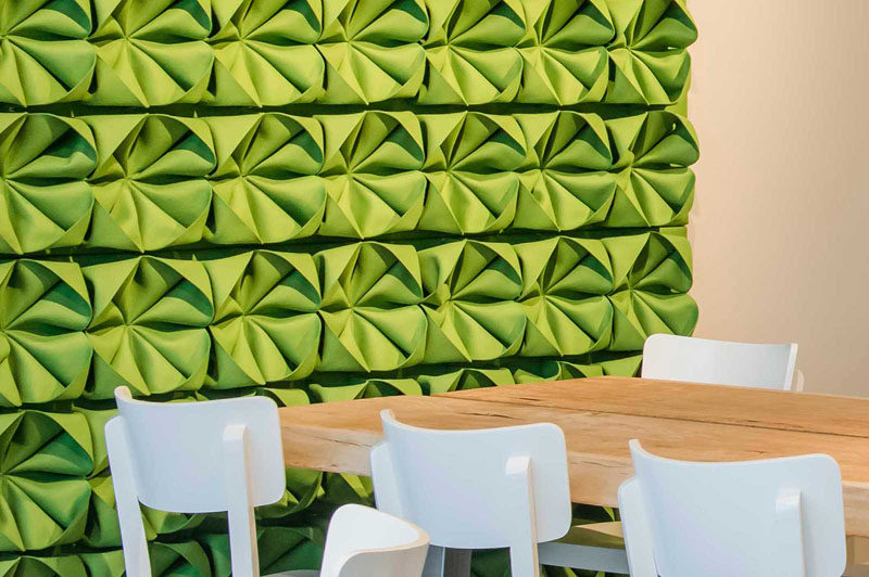 Intricately folded pieces of green felt attached to this accent wall give it dimension and texture, and brighten up the room.