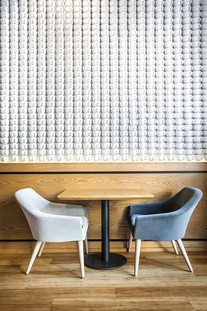 An accent wall in a coffee shop made from white teacups.