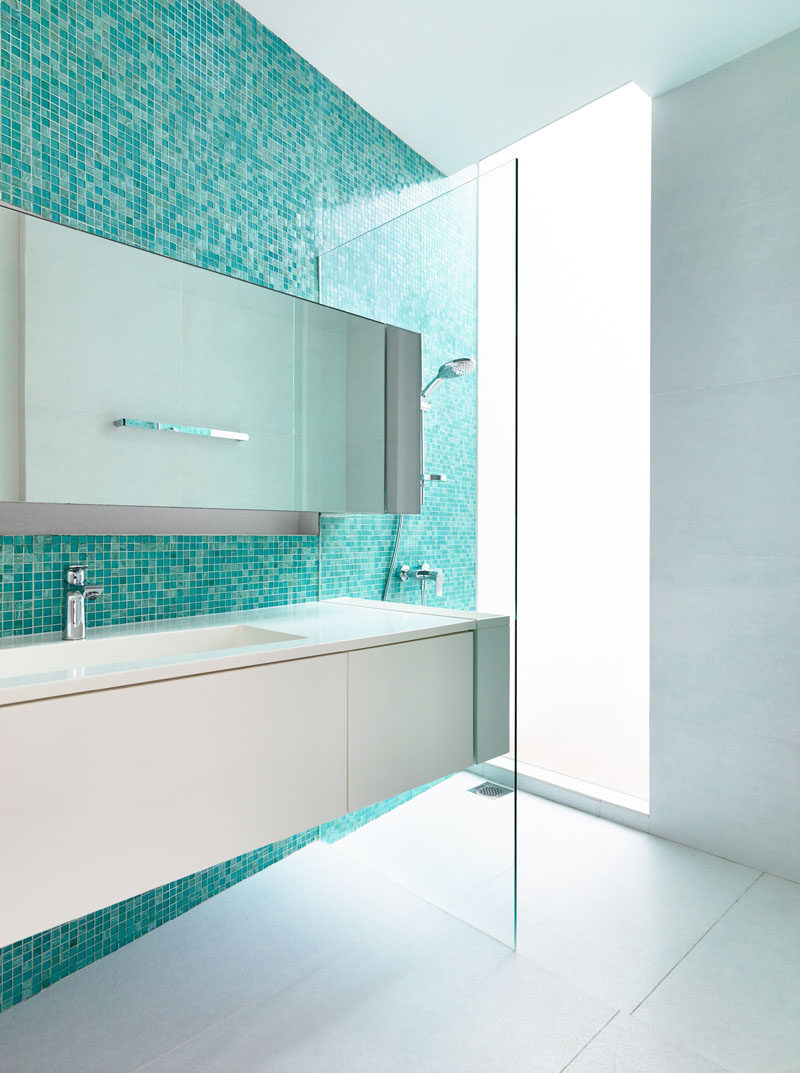 13 Inspirational Examples Of Blue And White Bathrooms // An accent wall of aqua blue tiles in this bathroom adds color and a focal point, as well as helps to create a relaxing little oasis.