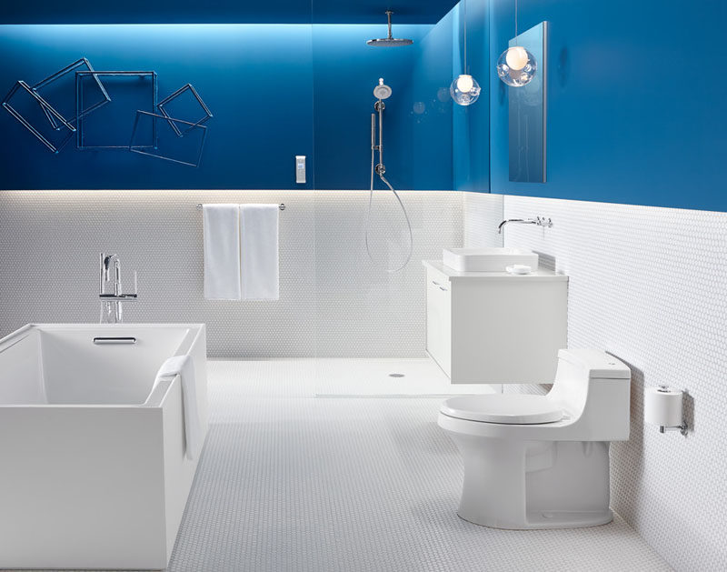 13 Inspirational Examples Of Blue And White Bathrooms // This all white bathroom is interrupted by a bold strip of blue that continues all the way to the ceiling.