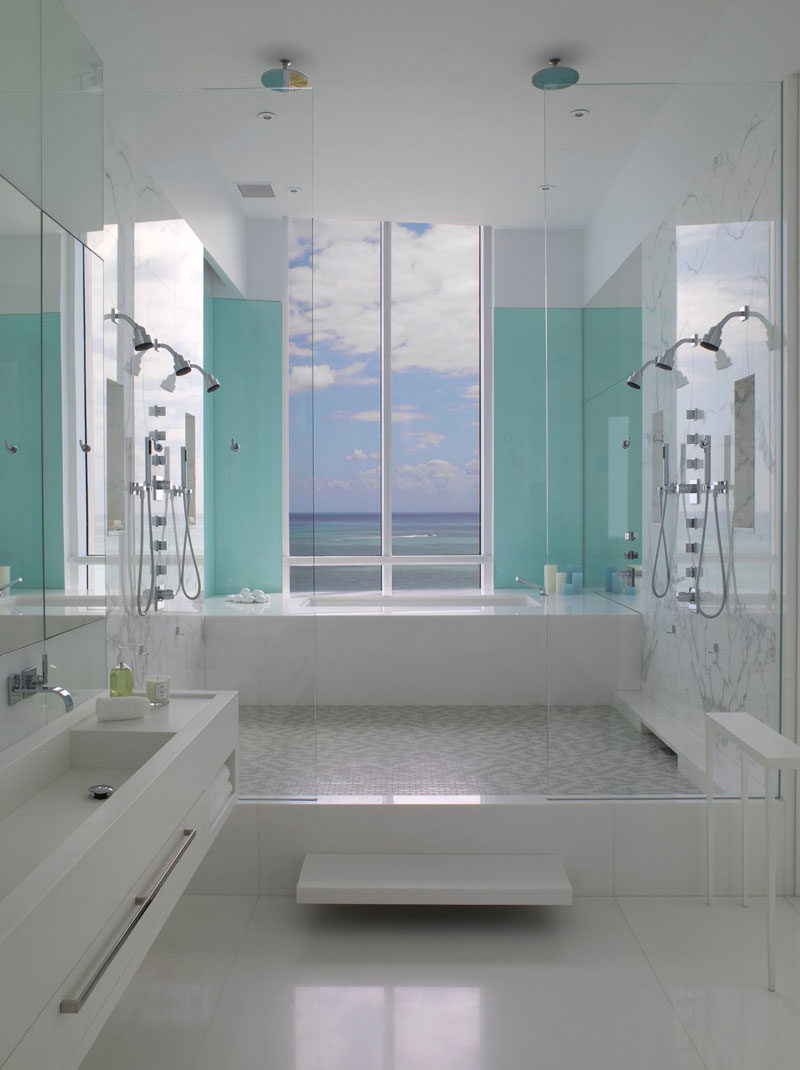 13 Inspirational Examples Of Blue And White Bathrooms // Two light blue panels flank the window of this bathroom, drawing your eye to the window and framing the incredible view just outside.