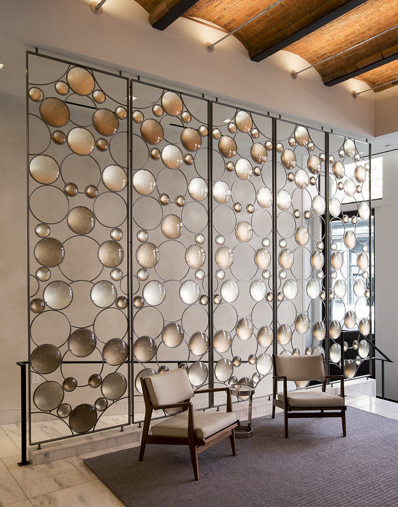 Room Divider Idea - Artist Christophe Côme created a 'Bubble Screen', made from iron, industrial crystal and molded glass lenses, that is art and also functions as a room divider in the lobby of a New York building.