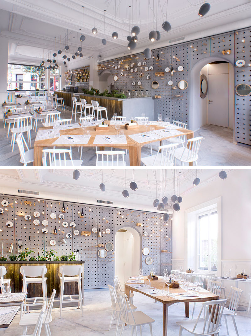 Wall Decor Idea - A gray perforated concrete pegboard lines the wall of this cafe for a unique shelving solution.