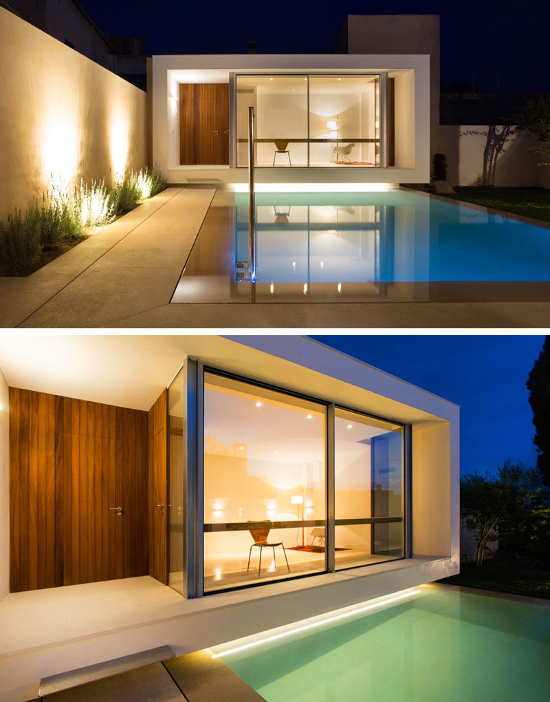 A small pool is positioned between a house and studio space, with lighting highlighting the dramatic design of the garden and patio.