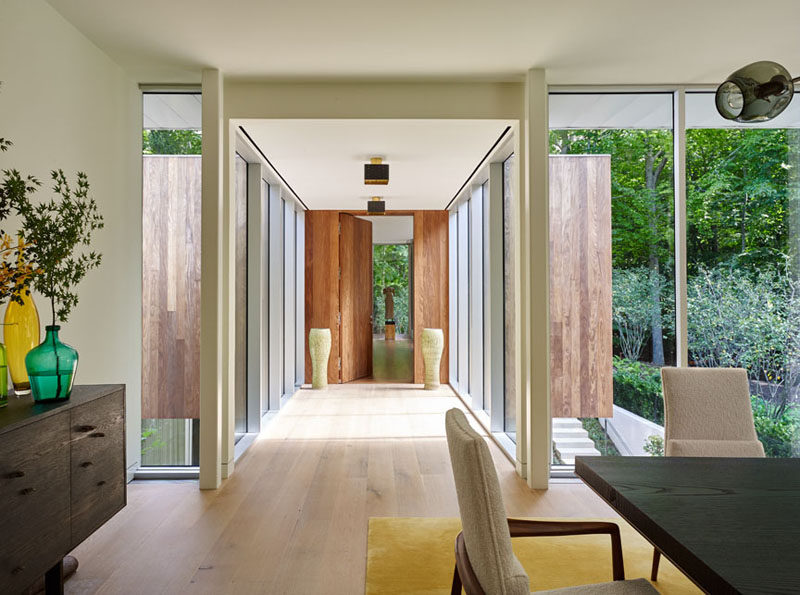 This home has a glass enclosed hallway that leads from the dining room to the bedroom.