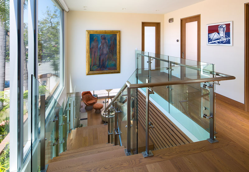 These wood stairs have wooden handrails and glass safety barriers.