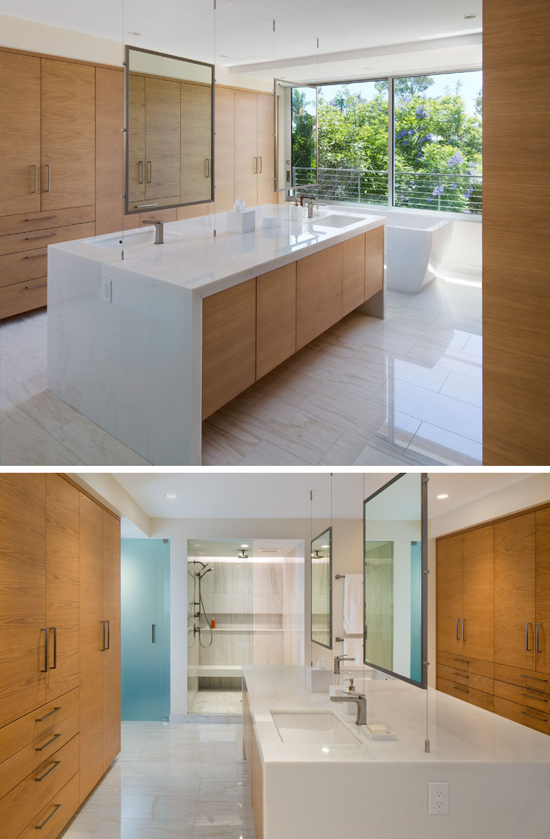 In this ensuite bathroom, there's a large central island vanity, that has a basin and mirror on each side.