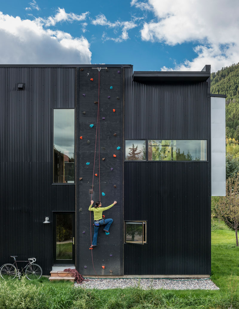 The exterior of the home is clad in black corrugated metal and was chosen for its durability, texture and low cost. Due to the height of the home, the designers were also able to install a climbing wall.