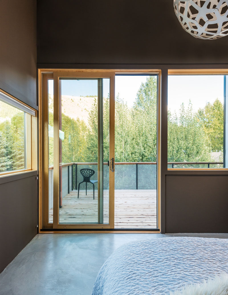 In this bedroom, windows and a private balcony provide views of the surrounding mountains.