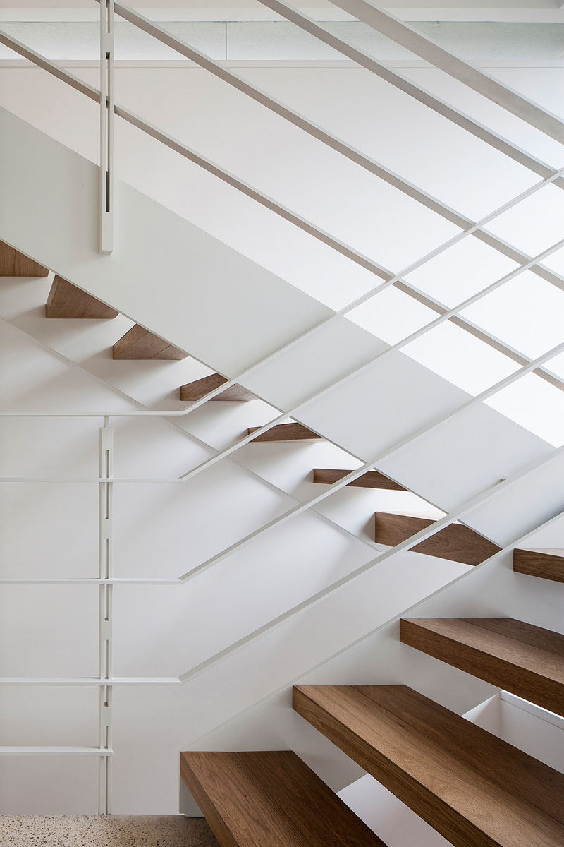 These stairs have wooden treads and metal handrails painted white.