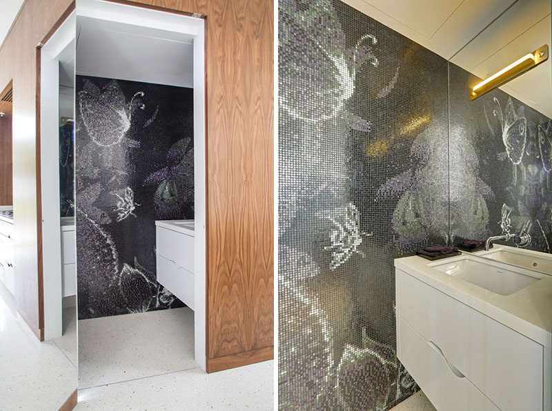 In this hidden bathroom there's a tile mural that covers the wall and adds an artistic element to the space.