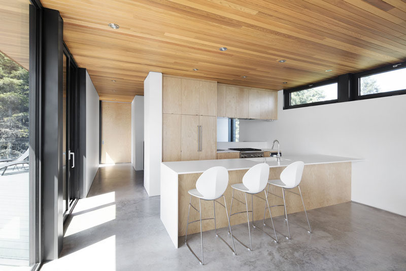 In this kitchen, light wood cabinetry has been combined with white walls and white countertops for a clean and contemporary look.