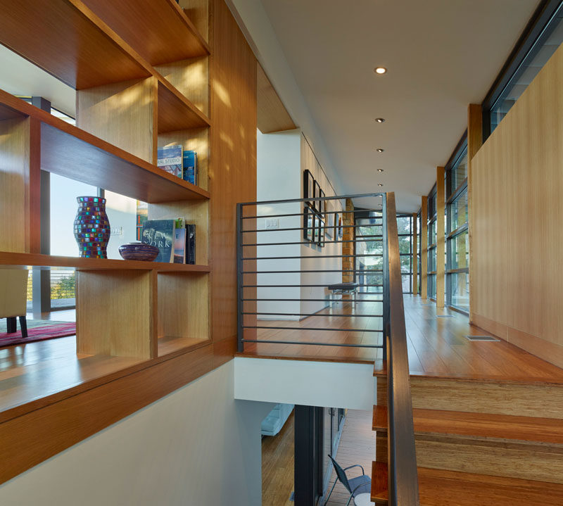 Custom shelving provides a separation between the front gallery-like entrance to the home, the stairs and the living room.